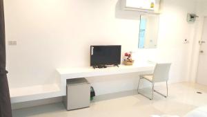 a computer monitor sitting on a white desk in a room at Mestyle Resort in Chumphon