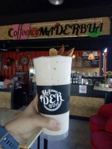 una persona sosteniendo un trago en una taza en Maderbua hotel, en Udon Thani