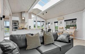 un soggiorno con divano in pelle e cucina di Holiday Home Lakolk Ix Denmark a Bolilmark