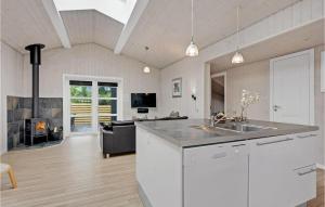 una cucina con lavandino e un soggiorno con camino di Holiday Home Lakolk Ix Denmark a Bolilmark Altre 18 foto