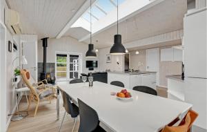 una cucina e una sala da pranzo con tavolo e sedie bianchi di Holiday Home Lakolk Ix Denmark a Bolilmark