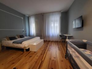Un dormitorio con dos camas y suelo de madera. en Godinho's House, en Matosinhos