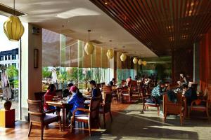 a group of people sitting at tables in a restaurant at Wuxi Shanse Hotel in Chizhou