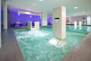 a swimming pool with a water fountain in a building at Hotel Parco Smeraldo Terme in Ischia