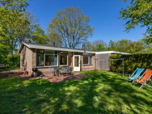 ein Haus mit einem Garten mit Stühlen und einem Haus in der Unterkunft Bungalow near Dutch Beach with Garden in Oostkapelle