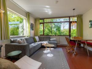 ein Wohnzimmer mit Sofa und Tisch in der Unterkunft Bungalow near Dutch Beach with Garden in Oostkapelle