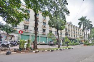 un edificio en una calle con árboles delante en Sleepzzz Hotel Senayan, en Yakarta