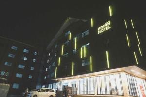 ein Gebäude mit einem davor geparkten Auto in der Unterkunft Prinn Hotel in Ban Thai Wat Khot