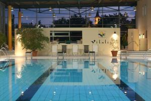 uma piscina com um bar ao fundo em Parkhotel Weiskirchen em Weiskirchen