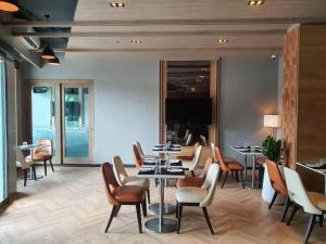 un ristorante con tavoli e sedie in una stanza di The Finn Hotel a Nakhon Ratchasima