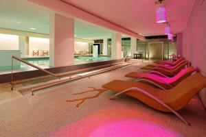 a row of chairs in a building with a swimming pool at Hotel Parco Smeraldo Terme in Ischia
