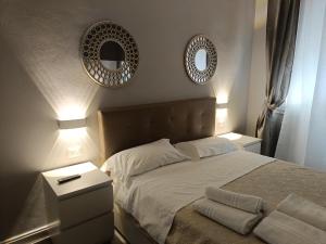 a bedroom with a bed with two mirrors on the wall at A casa di Rosy in Casalecchio di Reno