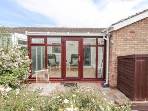 a conservatory with sliding glass doors on a house at Bedwine Cottage in Beadnell