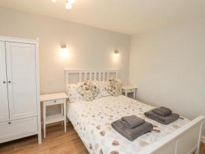 a bedroom with a bed with two pillows on it at Bedwine Cottage in Beadnell