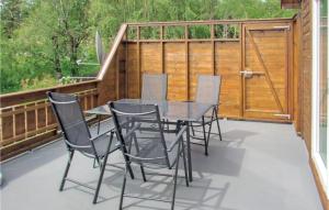 a patio with a table and chairs on a deck at Awesome Home In Kolnes in Eike