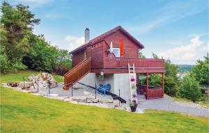 a small house with a deck and a staircase at Awesome Home In Kolnes in Eike