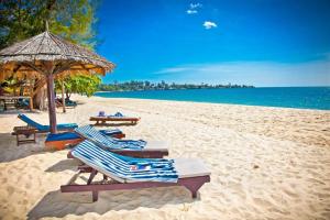 una playa con tumbonas, una sombrilla y el océano en Jin Bei Palace Hotel, en Sihanoukville