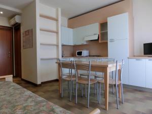 - une cuisine avec une table et des chaises dans la chambre dans l'établissement Salisburgo, à Lignano Sabbiadoro