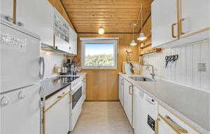 a kitchen with white appliances and a window at Holiday Home Holmsborgvej Ringkøbing X in Søndervig +17 photos
