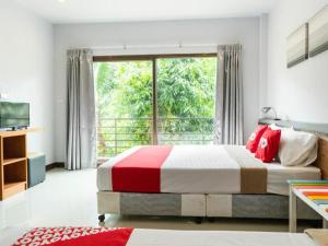 a bedroom with a bed and a large window at OYO 567 U Residence in Ban Lamai +55 photos