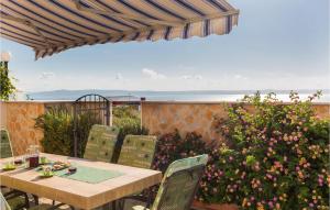 a patio with a table and chairs and flowers at 3 Bedroom Lovely Home In Makarska in Makarska