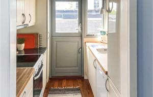 a small kitchen with a door and a sink at Holiday Home Kokhaven in Nordenhuse