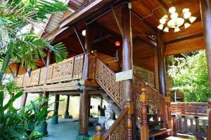 a large wooden house with a balcony on a house at Capital O923 Elephant at Baan Tawai in Bān Sawan