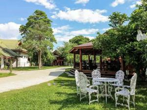 a table and chairs in front of a gazebo at Capital O923 Elephant at Baan Tawai in Bān Sawan
