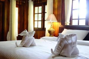 two pairs of shoes sitting on top of a bed at Capital O923 Elephant at Baan Tawai in Bān Sawan +18 photos