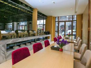 a dining room with a table and red chairs at Lavande Hotels·Qiannan Libo in Libo