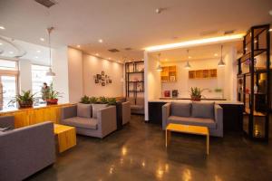 a living room with couches and tables and a kitchen at 7 Days Premium· Zhoushuizi Airport Wal-Mart in Dalian