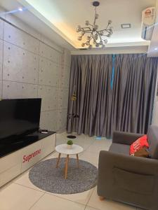 een woonkamer met een bank, een tv en een tafel bij SS Homestay in Kota Kinabalu