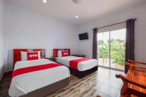 duas camas em um quarto com uma janela grande em OYO 1044 Vassana ResortÃ¢â‚¬â€¹ em Sattahip mais 38 fotografias