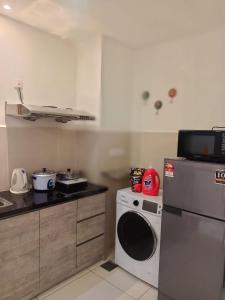 een keuken met een fornuis en een wasmachine bij SS Homestay in Kota Kinabalu