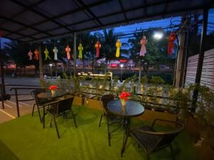 Dos mesas y sillas en un patio por la noche en P Bliss Hotel, en Phayao