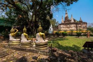 three statues in a park with a building in the background at OYO 1135 Triple A Residence in Chiang Mai