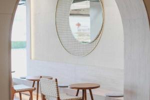 a mirror and two tables and chairs in a room at The One Hotel in Bung Kan