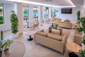 a lobby with couches and tables and potted plants at Hotel Mar Blau in Calella