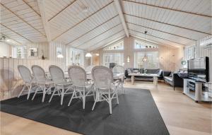 a dining room with chairs and a table and a couch at Holiday Home Bækholmen Ebeltoft I in Ebeltoft