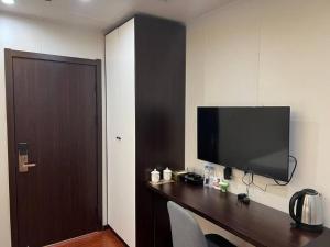 een kamer met een bureau met een televisie aan de muur bij Hotel 007 in Sihanoukville