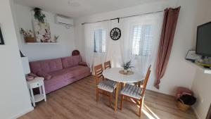 a living room with a table and a pink couch at Blue harmony 1 Malinska in Malinska
