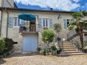 una casa de ladrillo con una puerta azul y un paraguas en Gîte 5 personnes, en Fleurville
