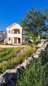 a house with a tree and a stone wall at Blue harmony 1 Malinska in Malinska