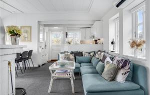 a living room with a blue couch and a table at 3 Bedroom Gorgeous Home In Ebeltoft in Ebeltoft