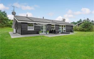 a small black house with a patio and grass at Amazing Home In Ebeltoft With Wifi in Ebeltoft +25 photos
