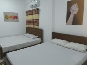 two beds in a small room with white walls at Surf reef beach in Trincomalee