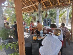 a group of people sitting at tables in a restaurant at Surf reef beach in Trincomalee