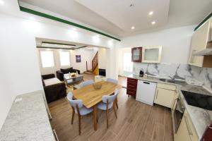 a kitchen and living room with a wooden table and chairs at Apartments Villa Begić in Sarajevo +58 photos