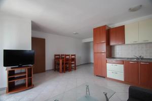 a kitchen with a flat screen tv and a kitchen with wooden cabinets at Apartment Kati in Novigrad Istria