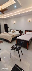 a bedroom with two beds and a chair in it at Saanvi Farmhouse in Hampi